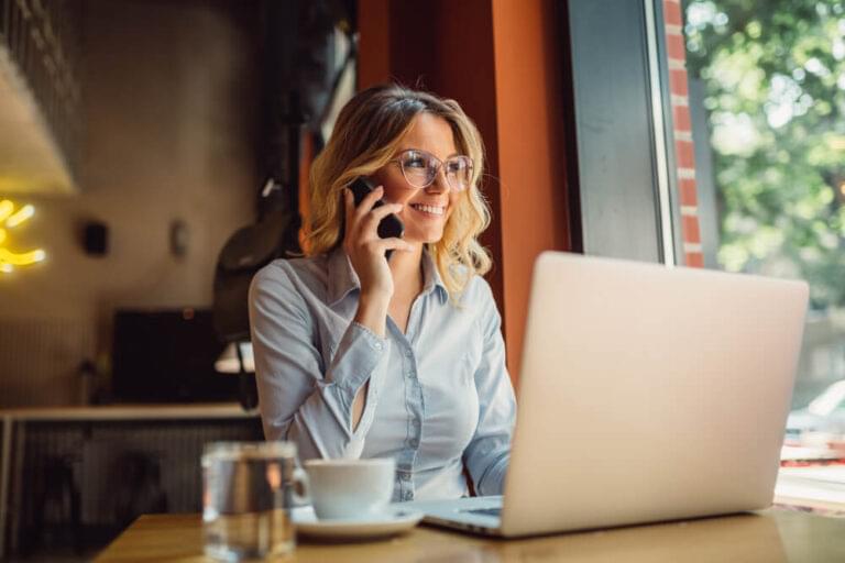 Portrait of young business woman with glasses sitting in cafe